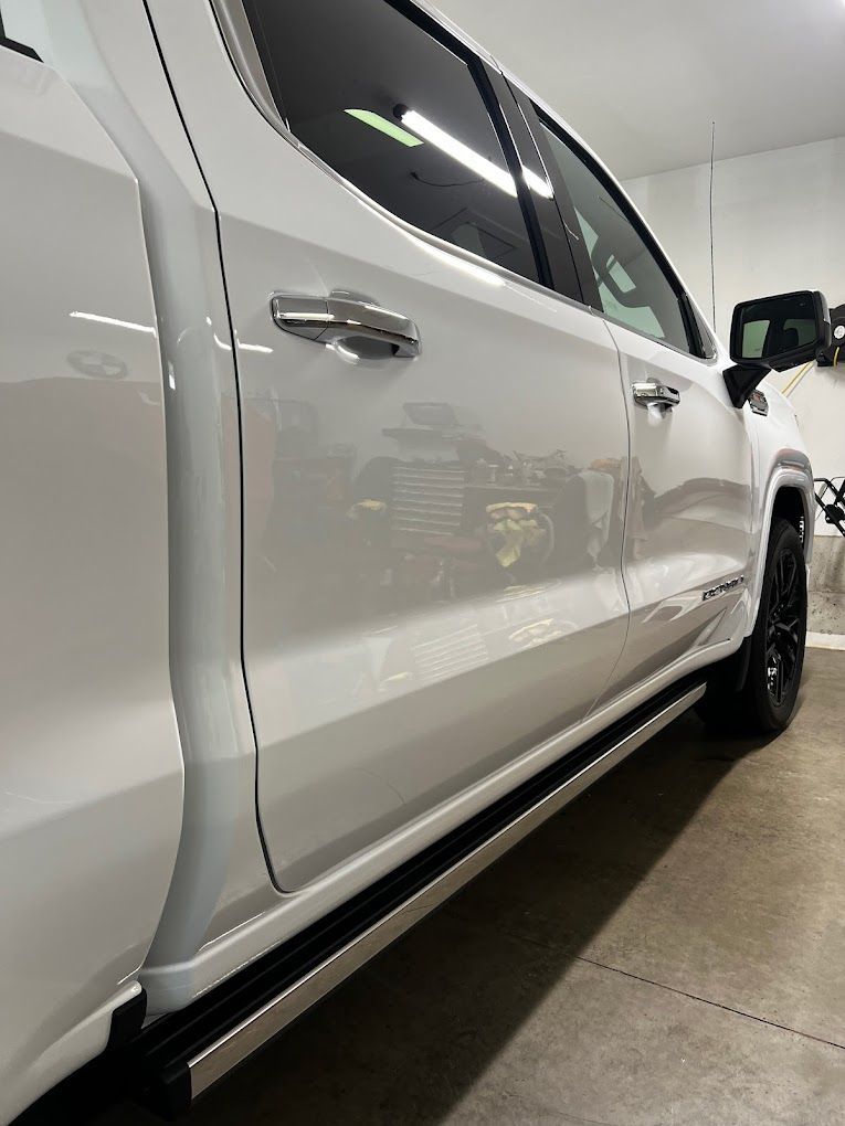 A white truck is parked in a garage.