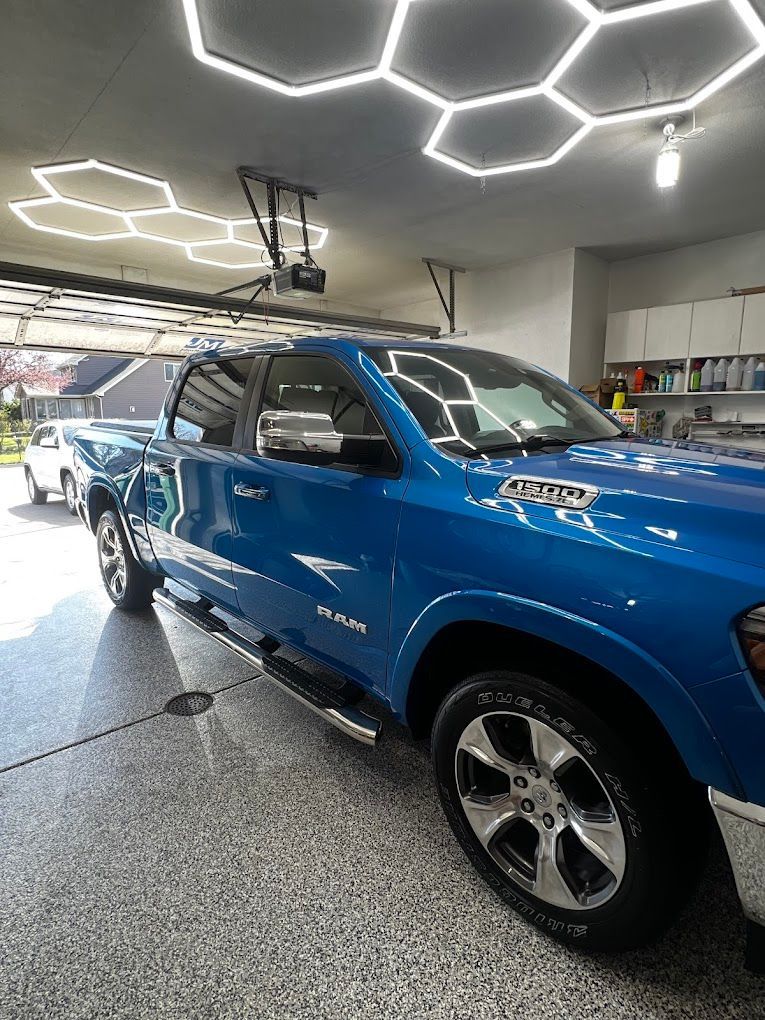 A blue ram truck is parked in a garage.