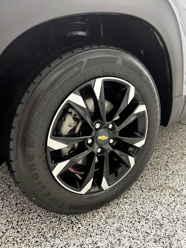 A close up of a tire on a car in a garage.