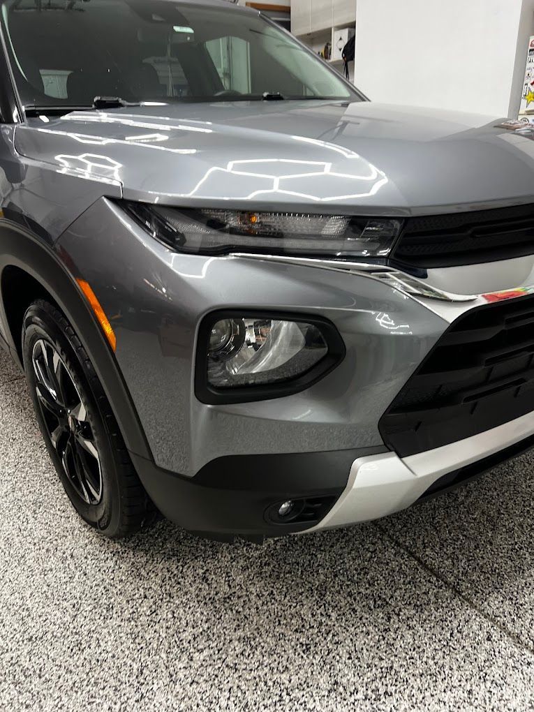 A gray chevrolet trailblazer is parked in a garage.