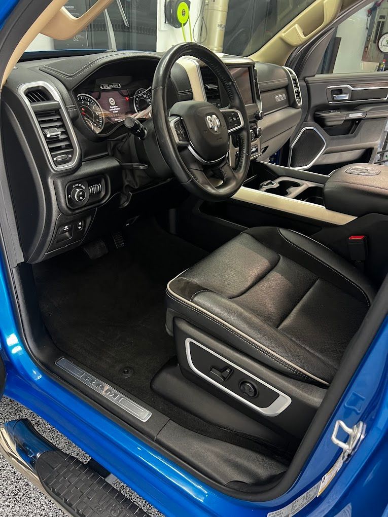 The interior of a blue ram truck with the door open.