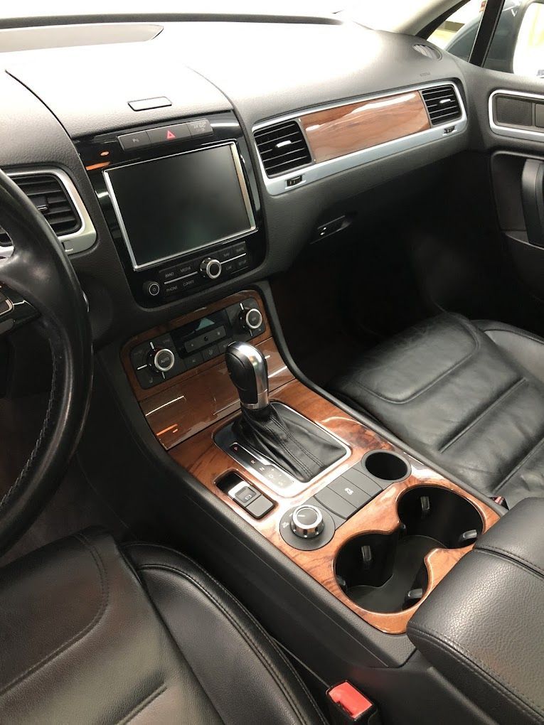 The interior of a volkswagen touareg with leather seats and wooden trim.