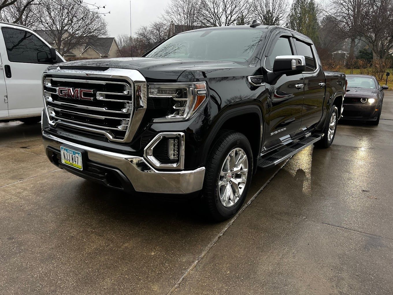 A black gmc sierra pickup truck is parked in a parking lot.