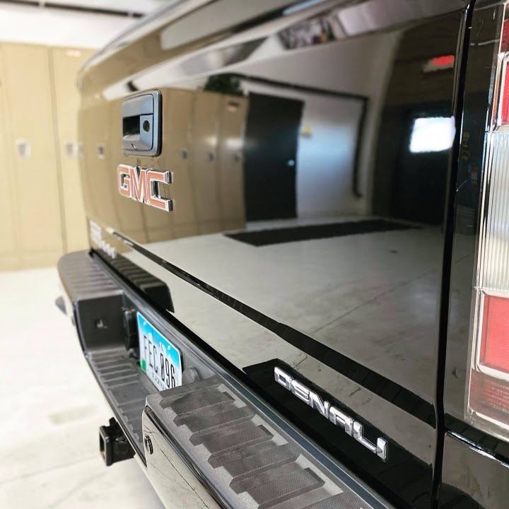 A black gmc truck is parked in a garage