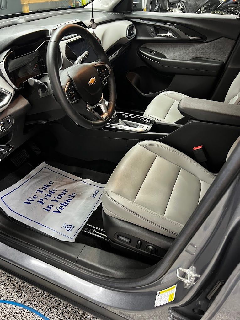The inside of a car with a steering wheel and seats
