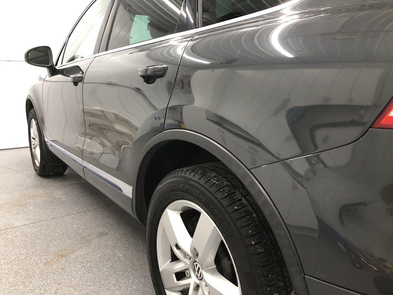 A close up of a car 's fender in a garage.