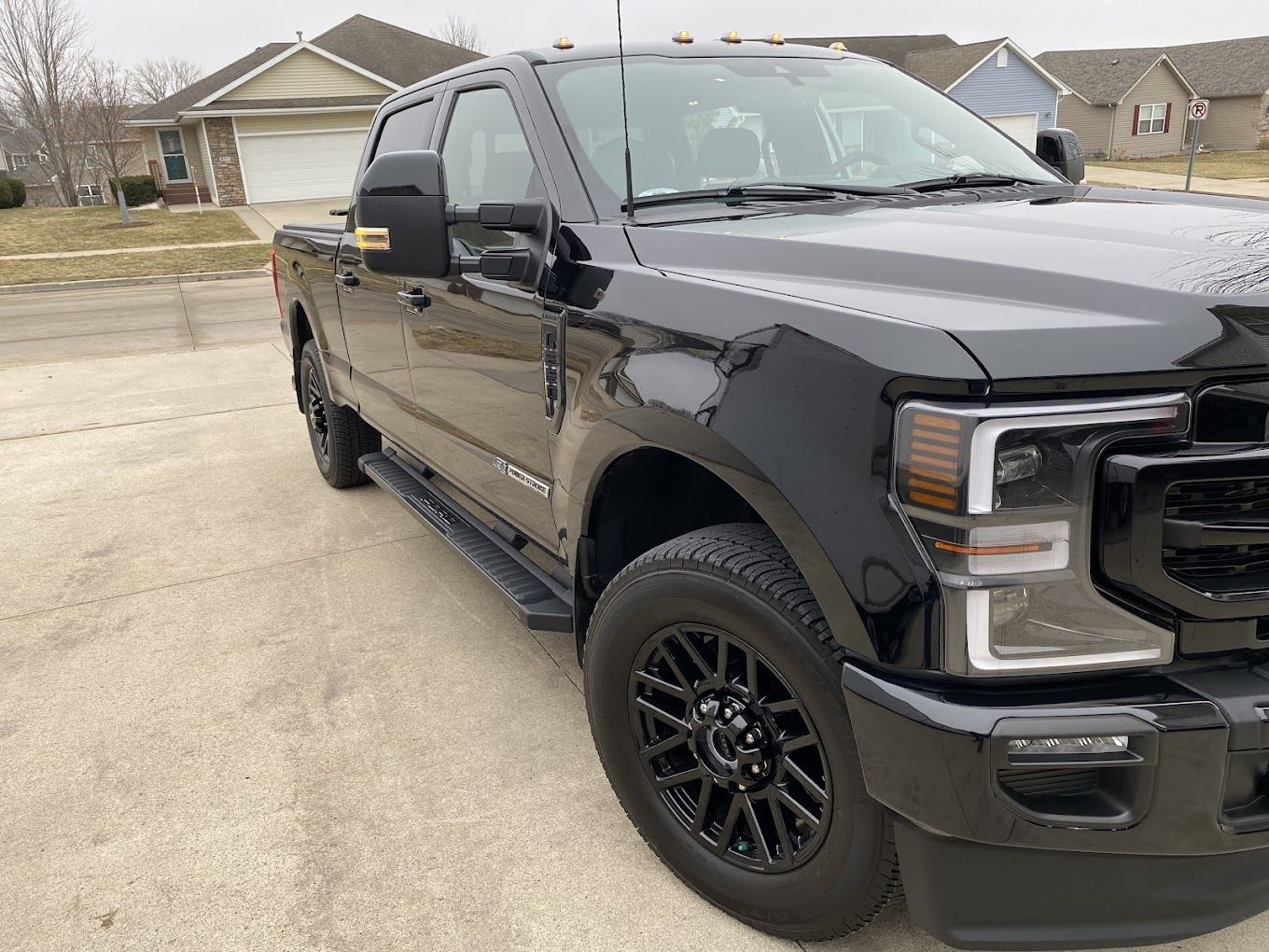 A black pickup truck is parked in front of a house.