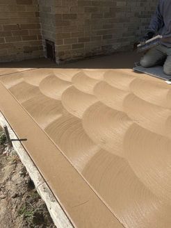 A person is laying concrete on a sidewalk with a pattern on it.