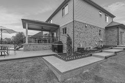 A black and white photo of a house with a patio.