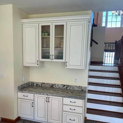 A kitchen with white cabinets , granite counter tops , stainless steel appliances and a sink.
