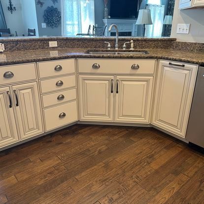 A kitchen with white cabinets and a granite counter top.
