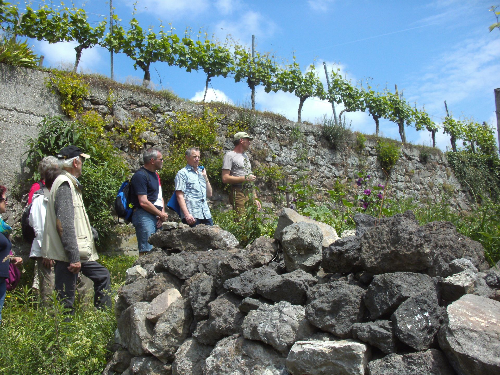 Eine Gruppe von Menschen steht um einen Steinhaufen herum.