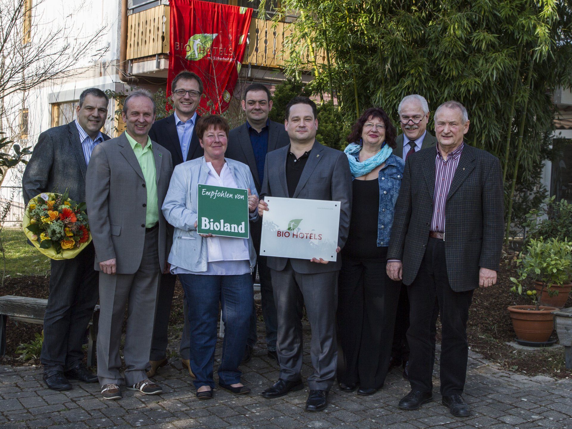 Eine Gruppe von Menschen steht nebeneinander und hält ein Schild mit der Aufschrift „Bioland“