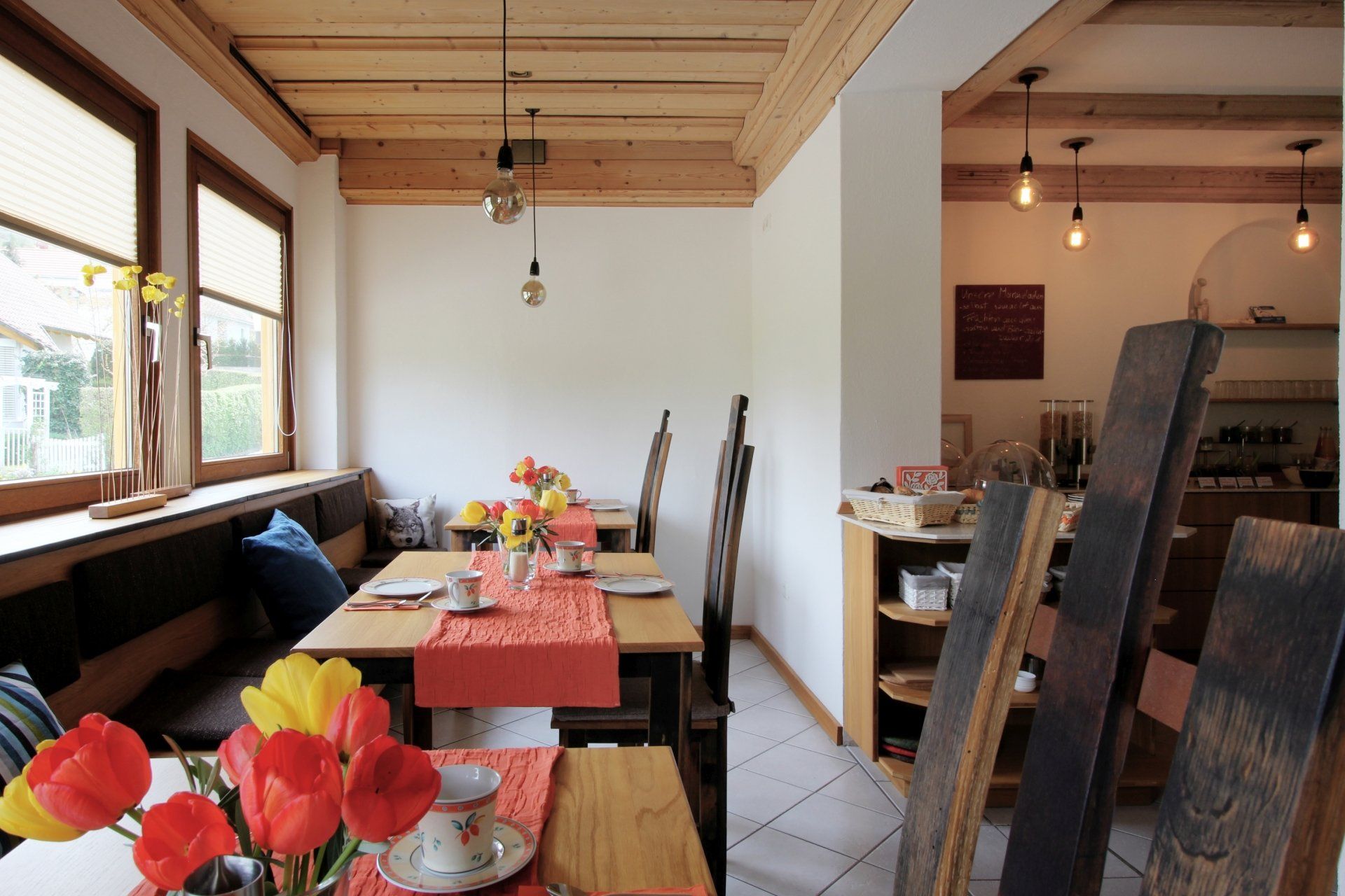 Ein Esszimmer mit Tischen und Stühlen und Blumen auf dem Tisch