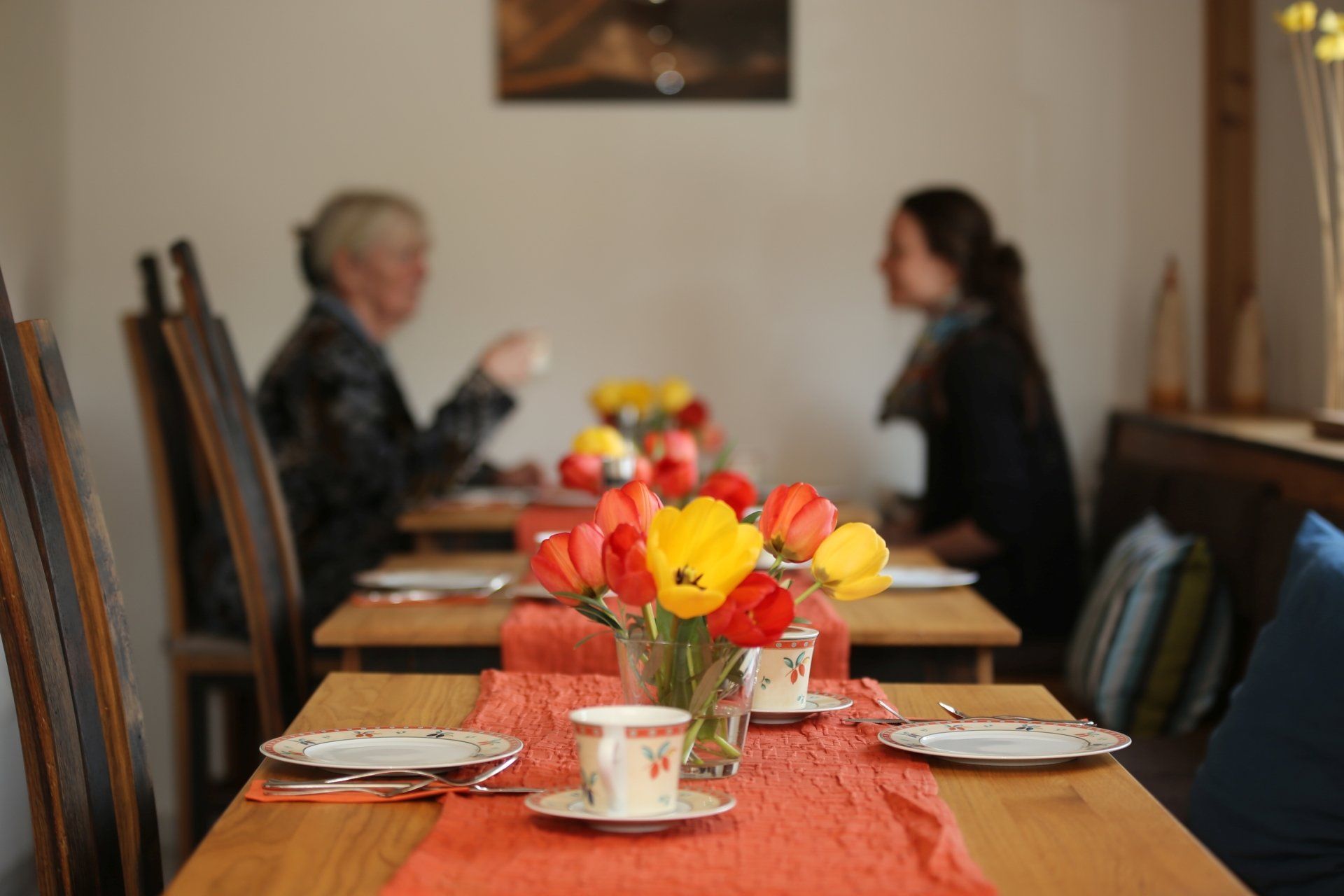 Ein langer Tisch mit einer Vase mit Blumen darauf