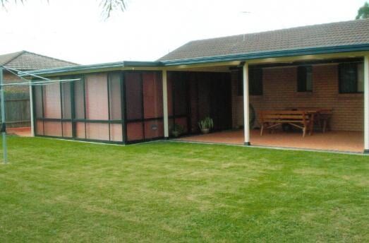 A House With a Screened in Porch and a Lawn in Front of It — Hunter & Mid Coast Patios In Lake Macquarie, NSW