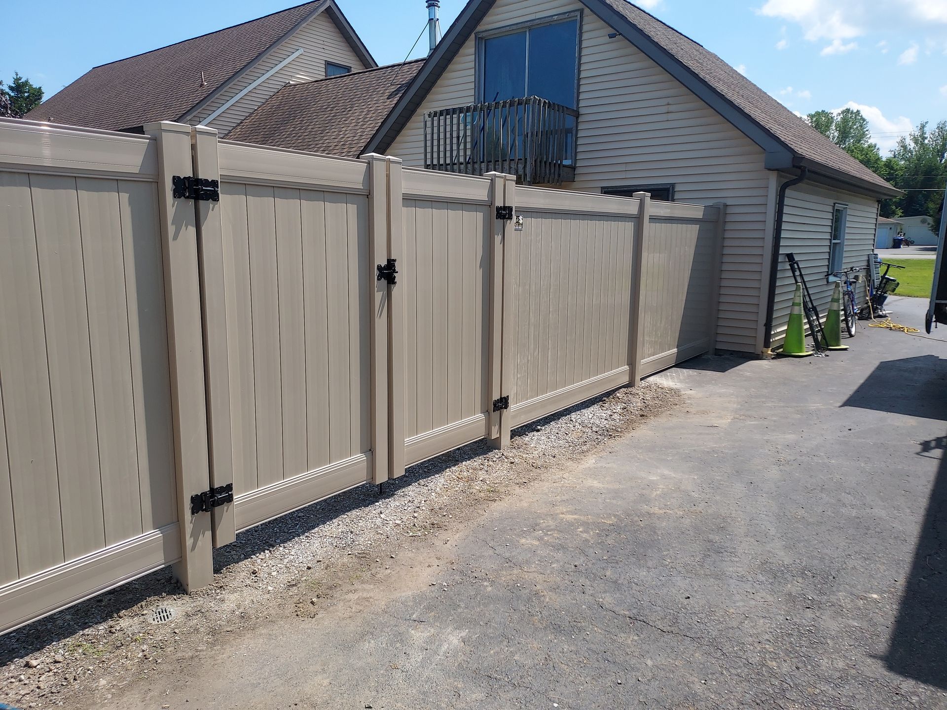 A wooden fence with a gate is in front of a house.