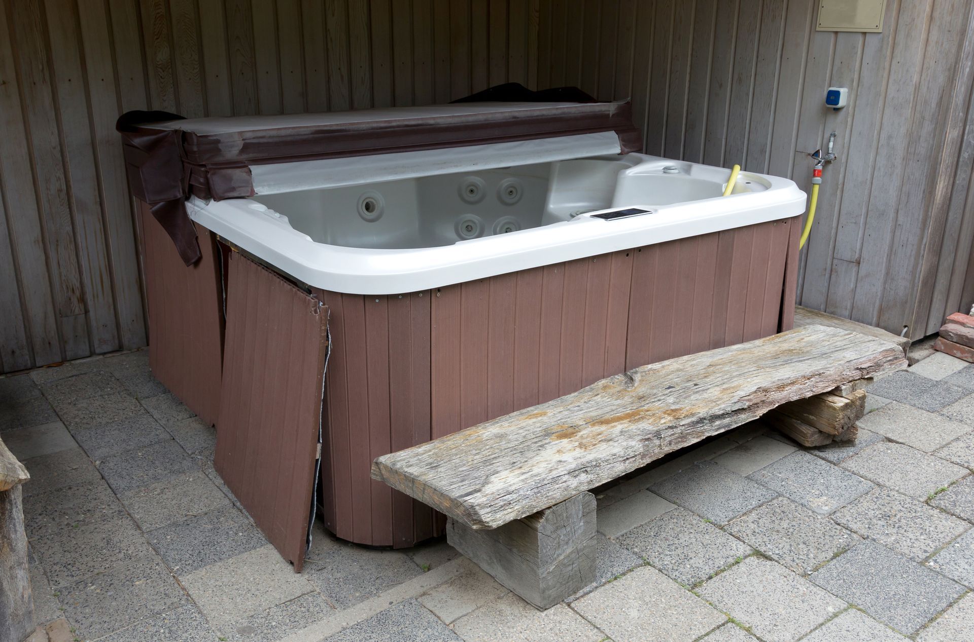 A hot tub with a wooden bench in front of it