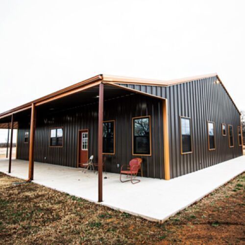 Barndominium with a porch, concrete foundation, Red door and trim, brown metal siding.