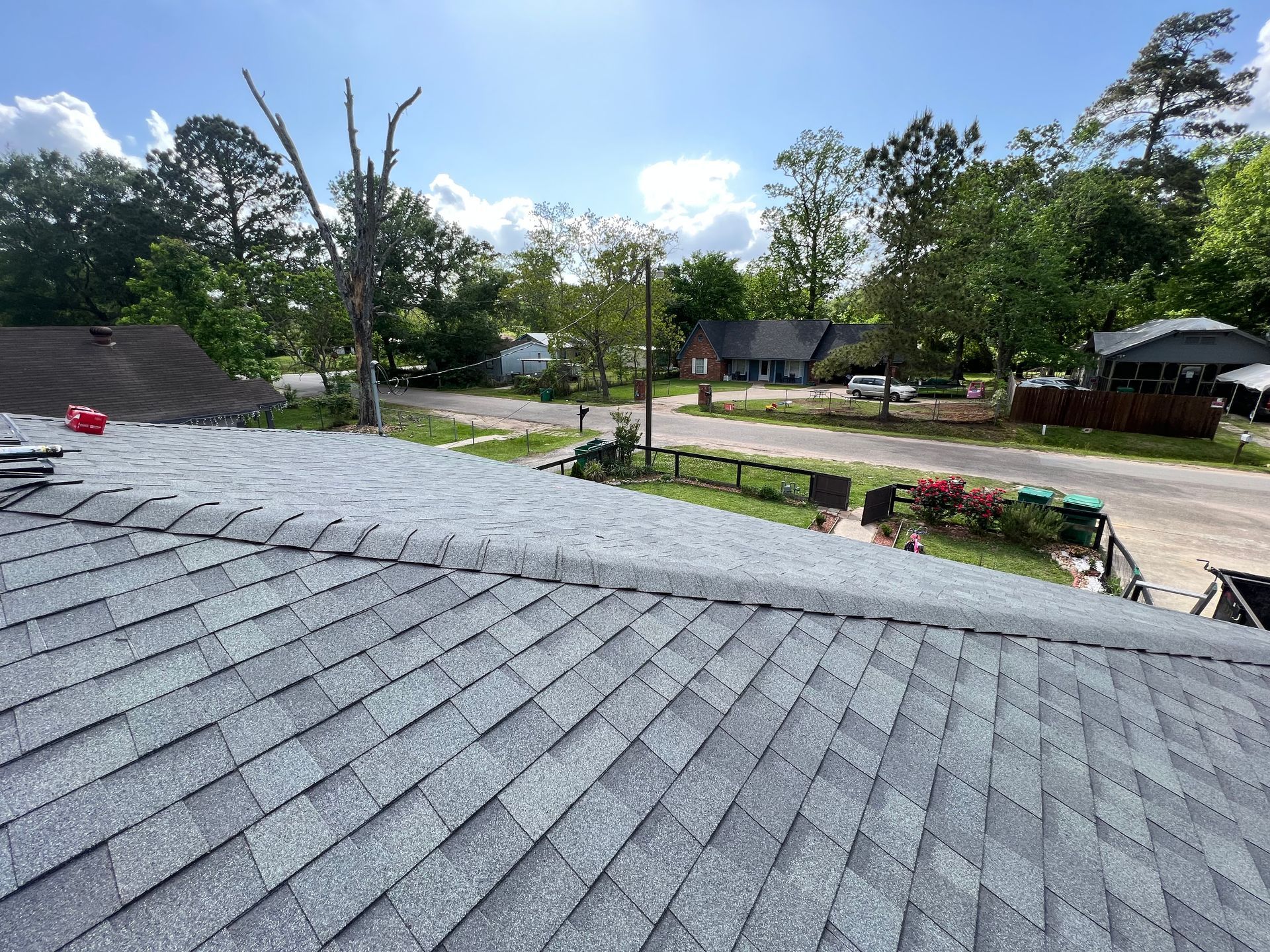 View from a rooftop: gray shingle roof replacement