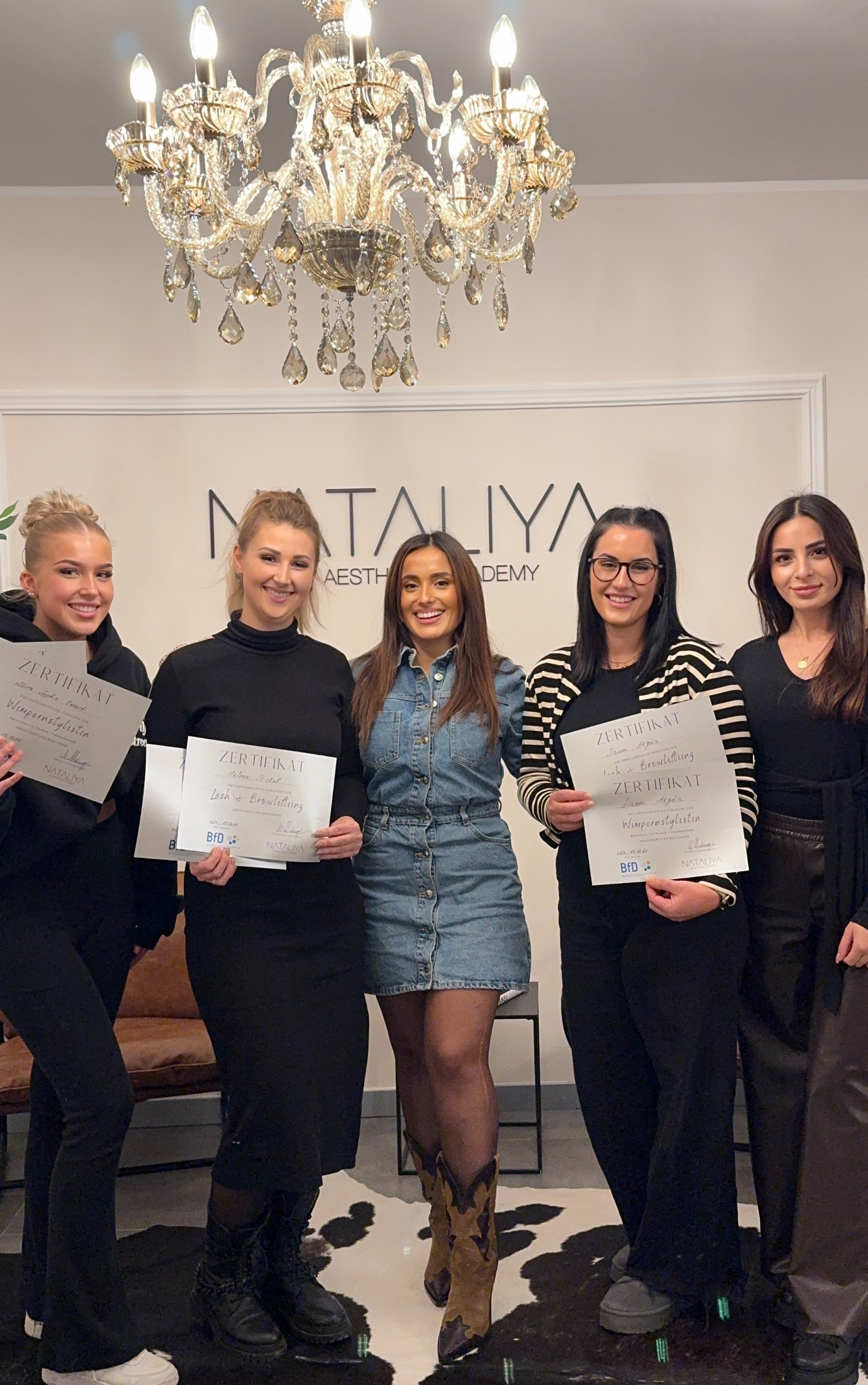 Eine Gruppe von Frauen steht nebeneinander vor einem Schild mit der Aufschrift „Natalia“