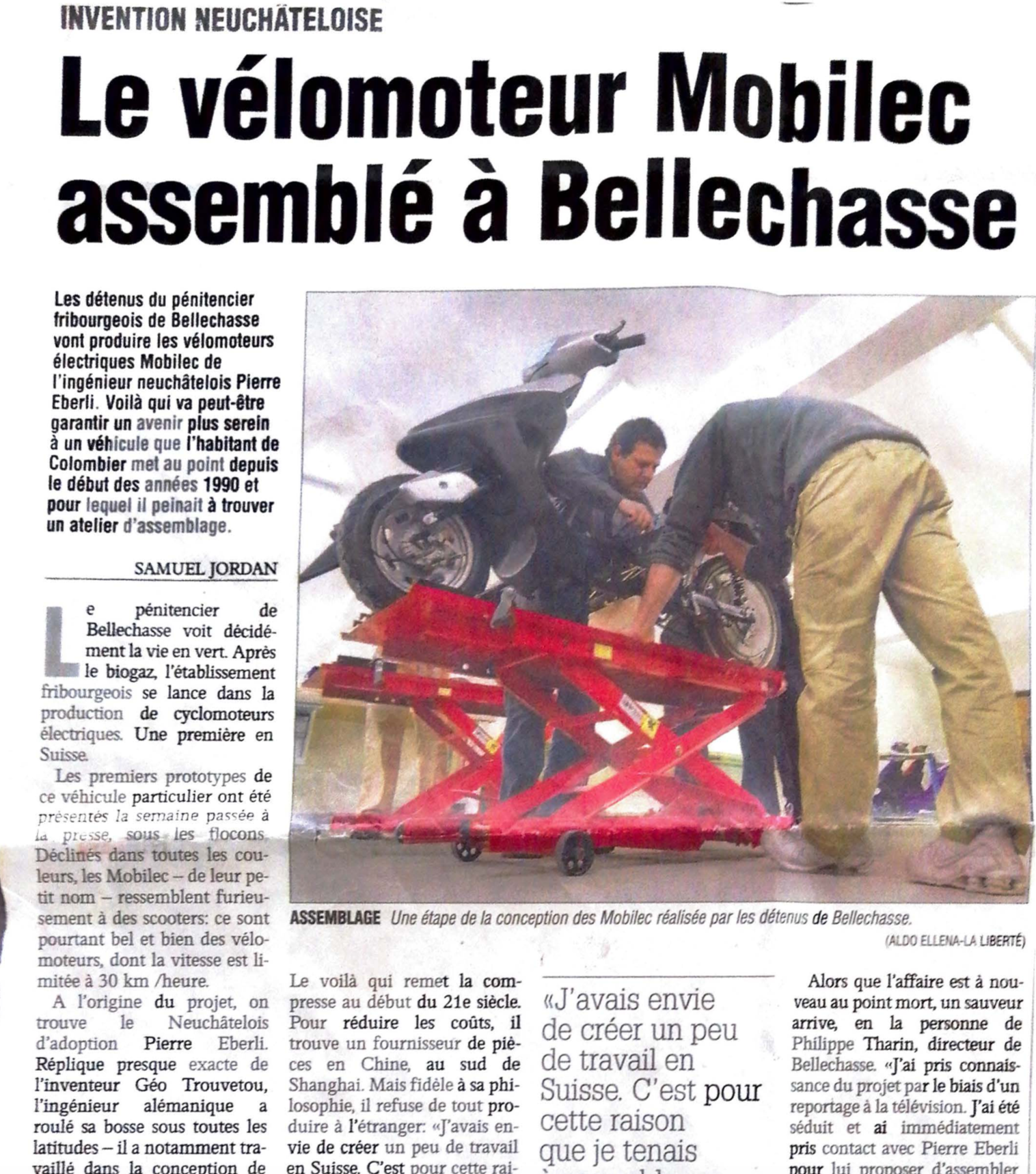 Deux hommes travaillent sur une moto dans un article de journal.