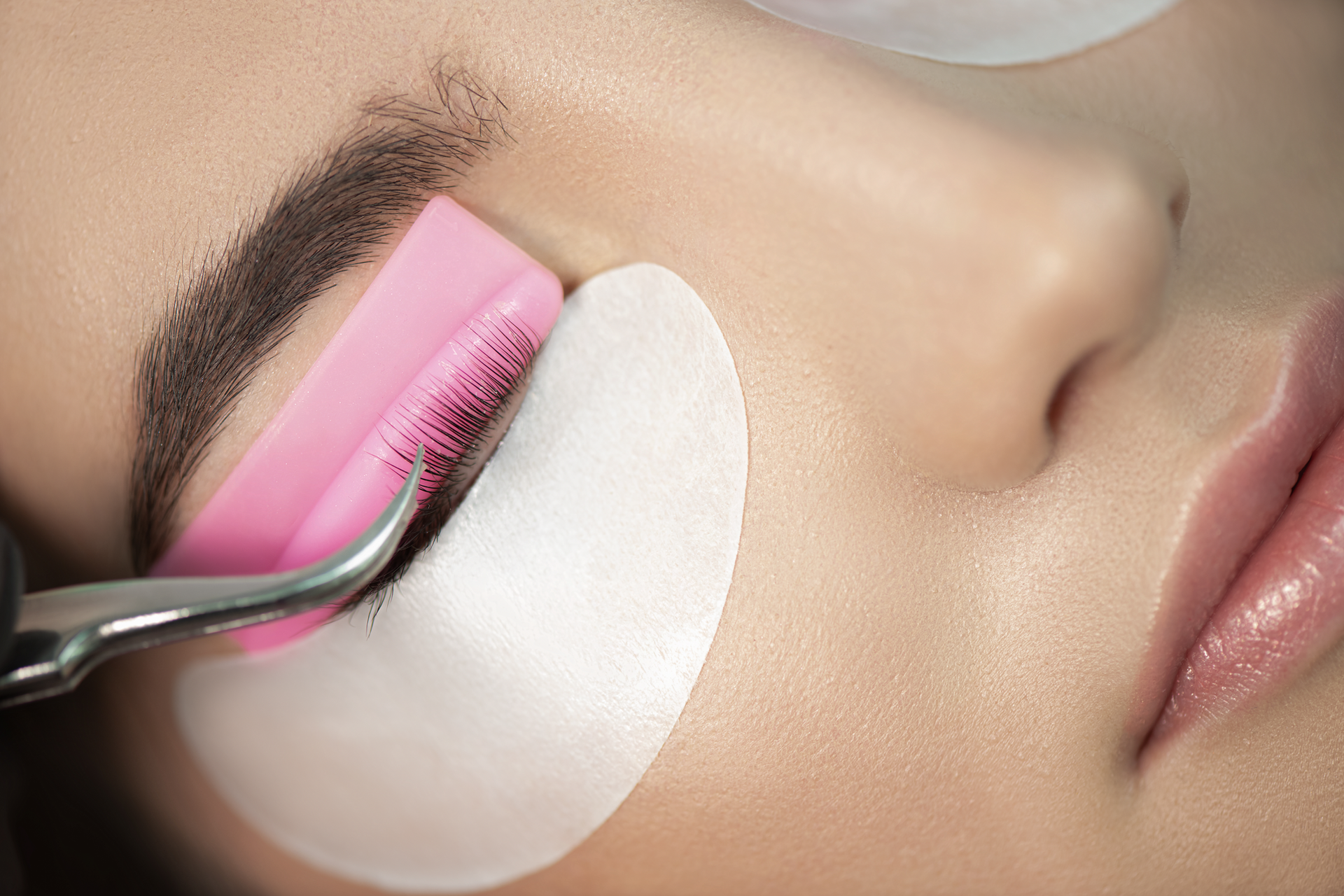 A close up of a woman getting eyelash extensions.