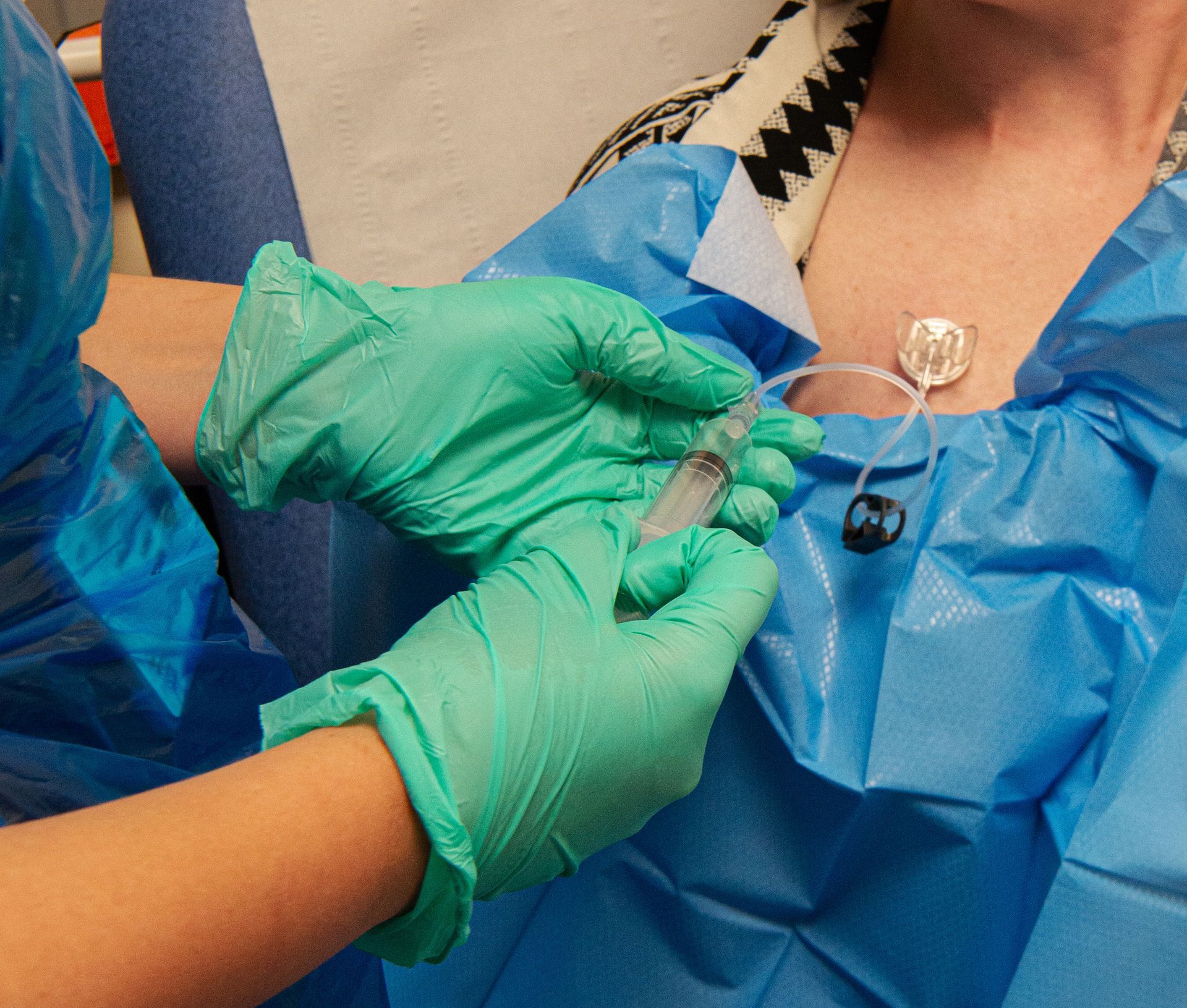 A nurse wearing gloves is tending to a patient