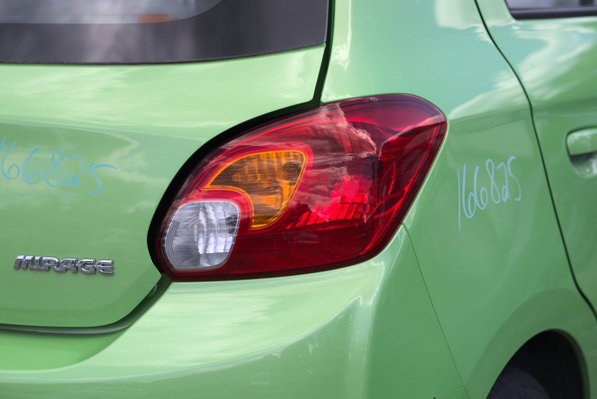 Mechanic with car bumper in a workshop