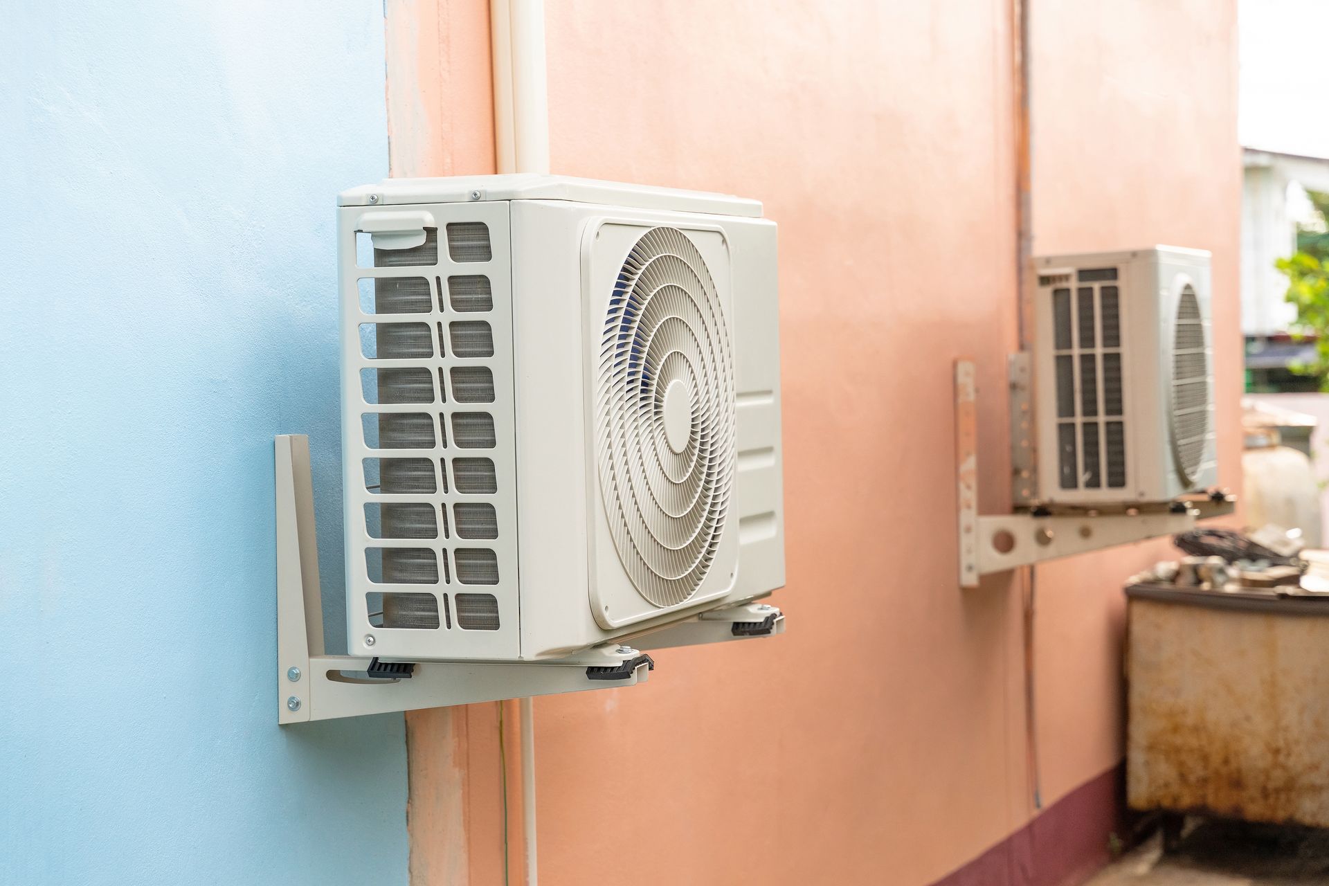 Two air conditioners are mounted on the side of a building. Products sold by Xtreme Air in Tempe, AZ