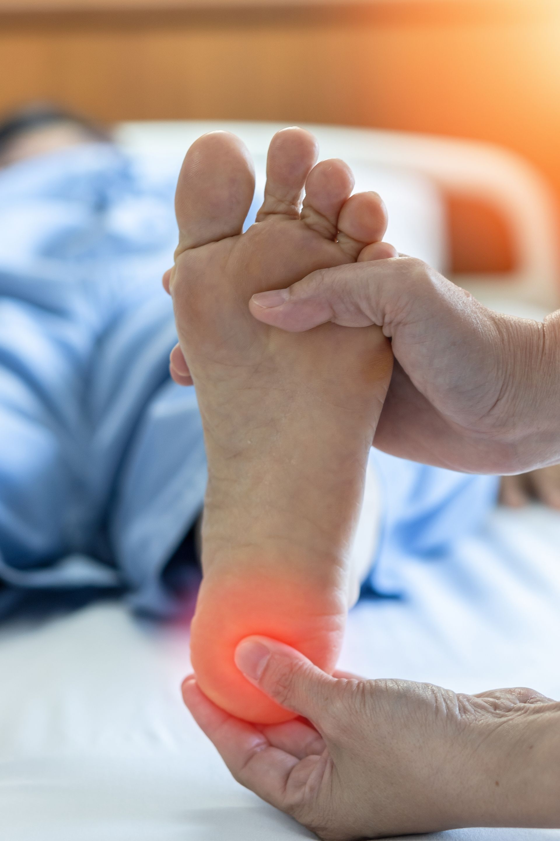 Hands Examining a Foot, Highlighting Red in the Heel Area — Dive Chiropractic in Mermaid Beach, QLD