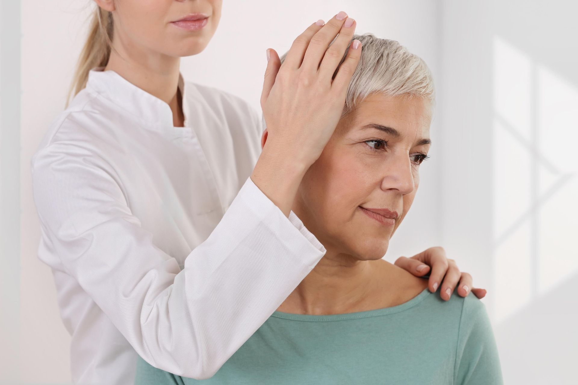 Healthcare Provider Gently Examines a Patient’s Head — Dive Chiropractic in Mermaid Beach, QLD