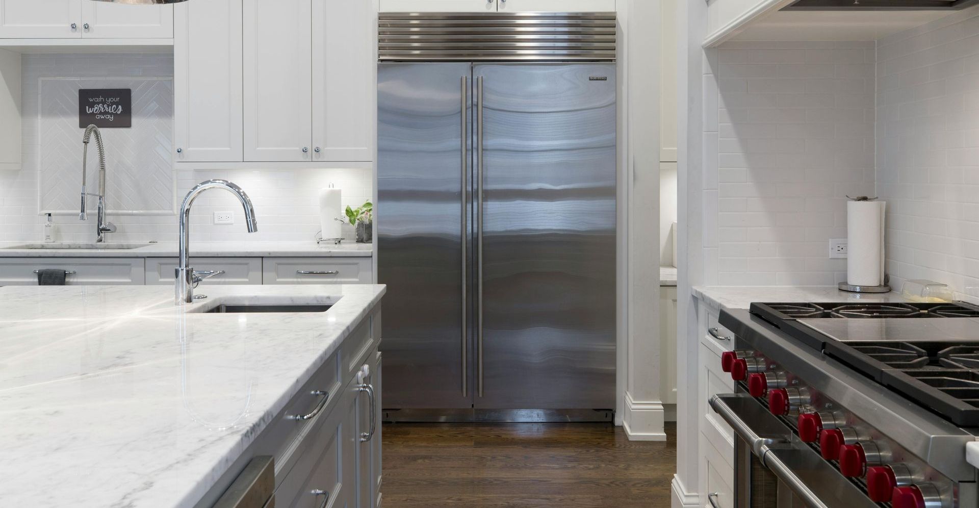 A kitchen with a stainless steel refrigerator , stove and sink.