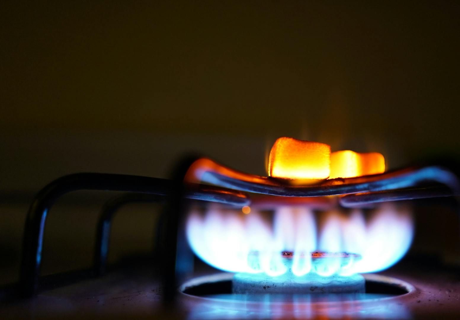 A close up of a gas stove with flames coming out of it.