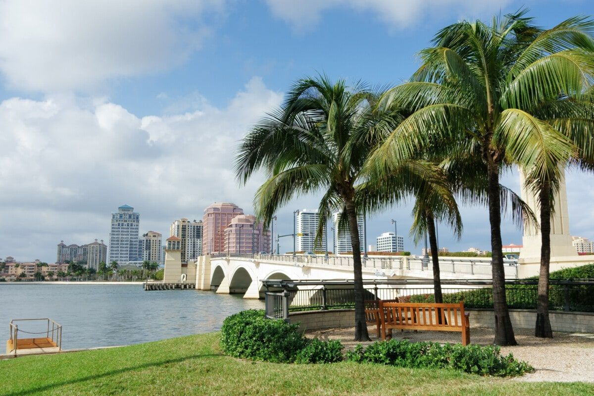 The Palm Coast skyline is reflected in a body of water.