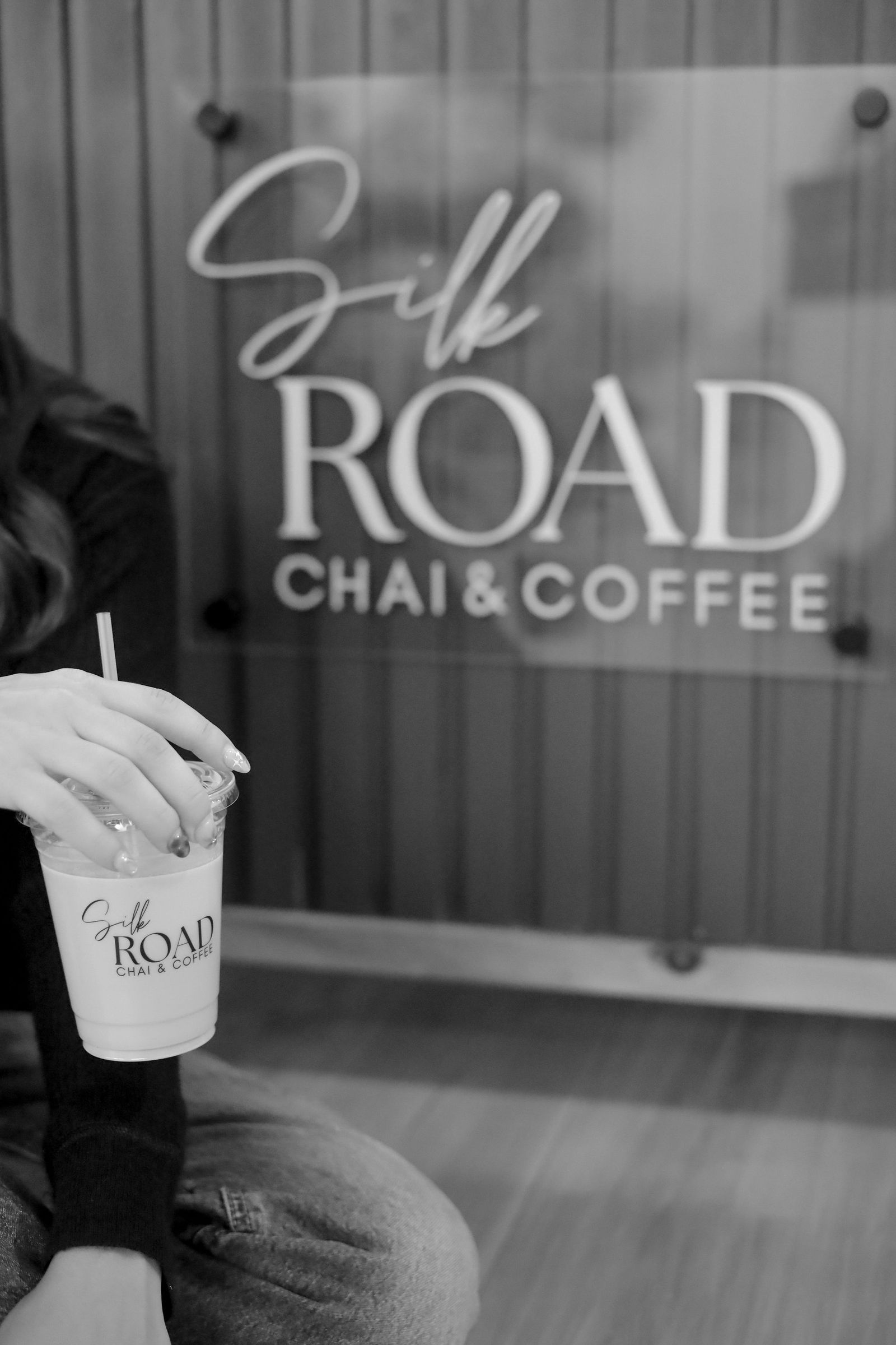 Woman holding a beverage in front of a 