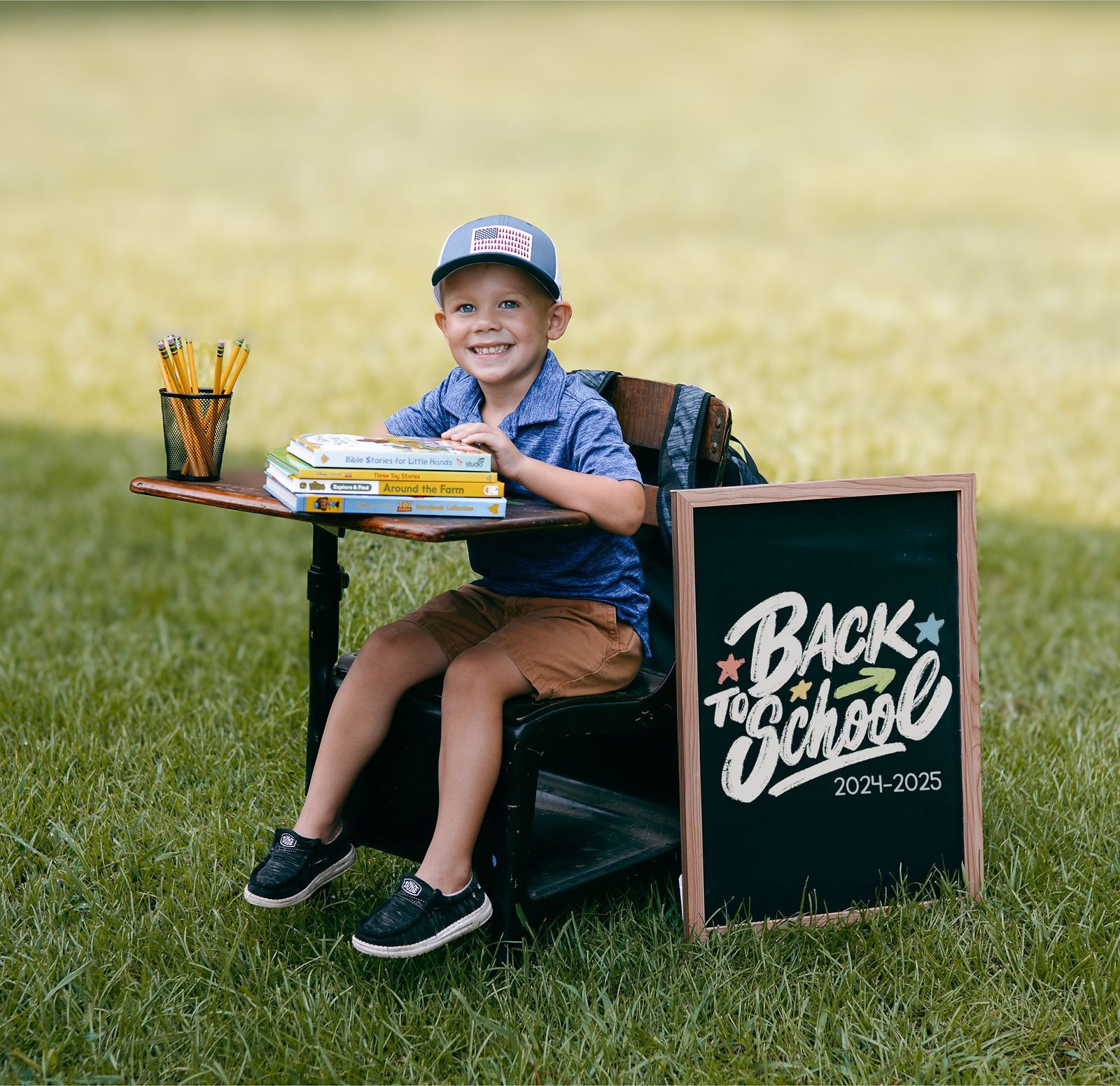 Young child smiles at desk with 