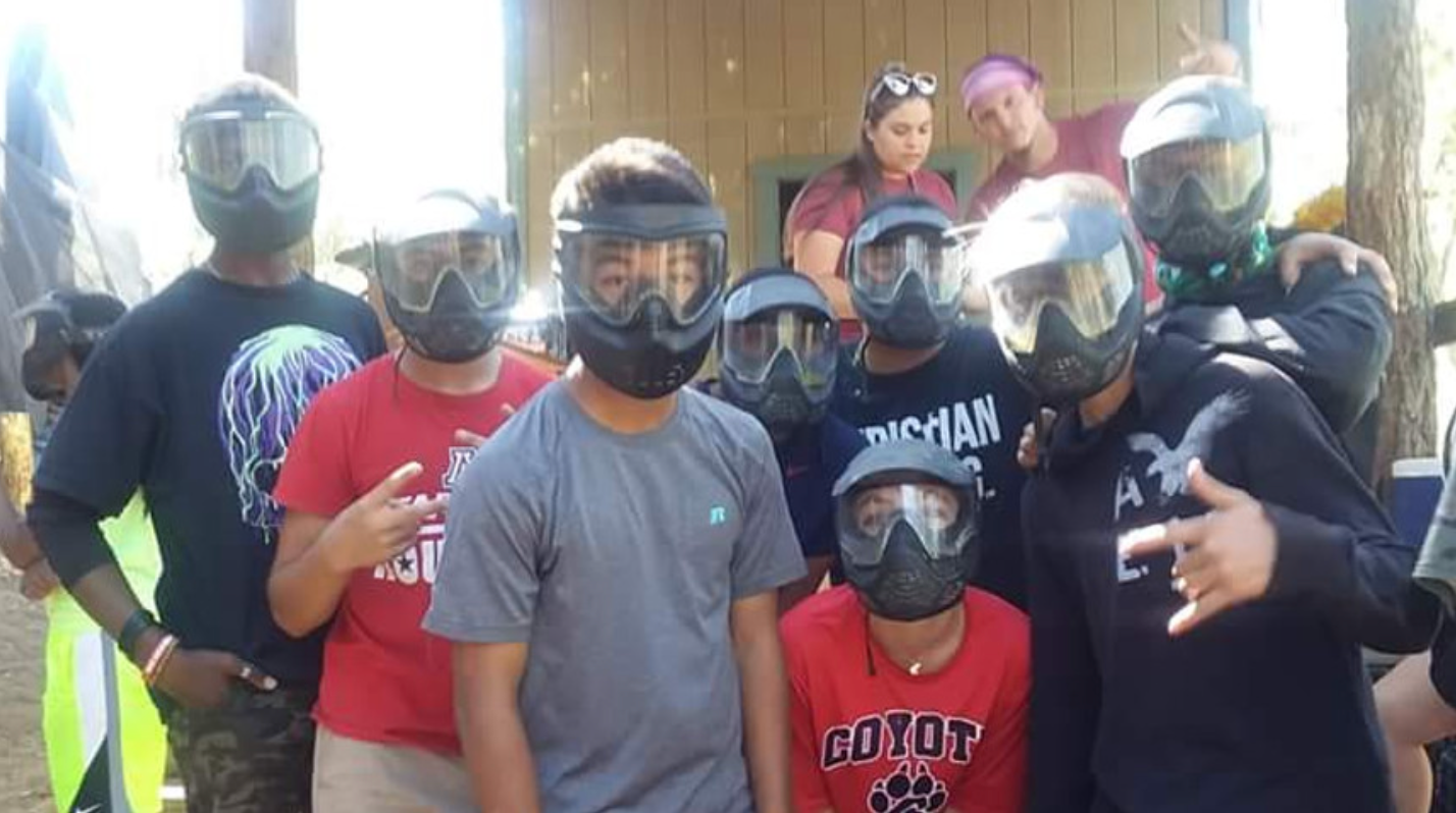 A group of people wearing paintball masks are posing for a picture.
