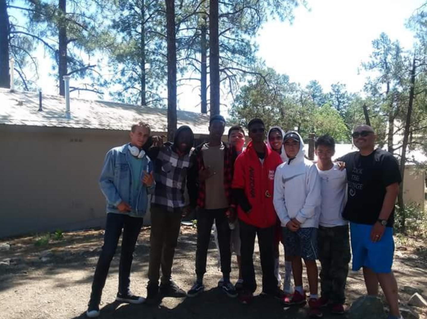 A group of people posing for a picture in front of trees