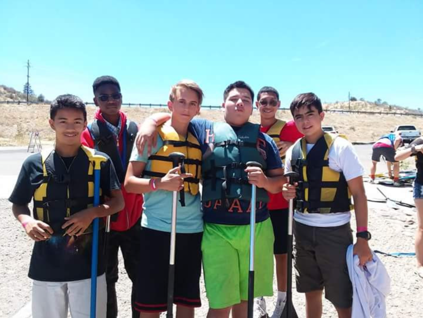A group of young men are posing for a picture and one of them is wearing a shirt that says pa