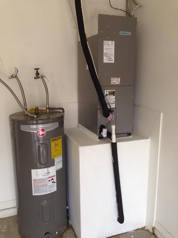 Water heater and furnace in a utility closet, with a black insulated pipe running up the wall.