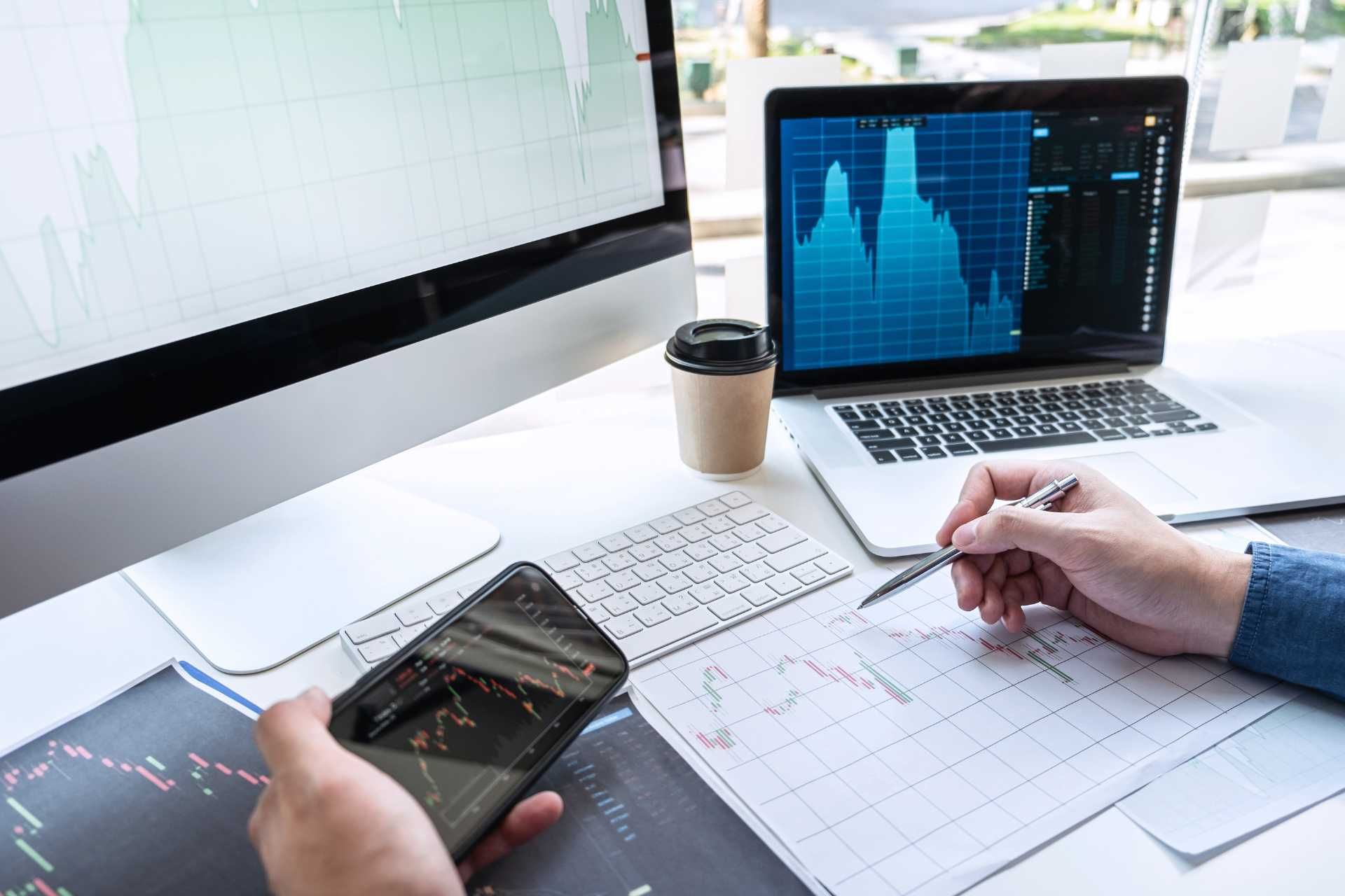a person is looking at a cell phone and a laptop