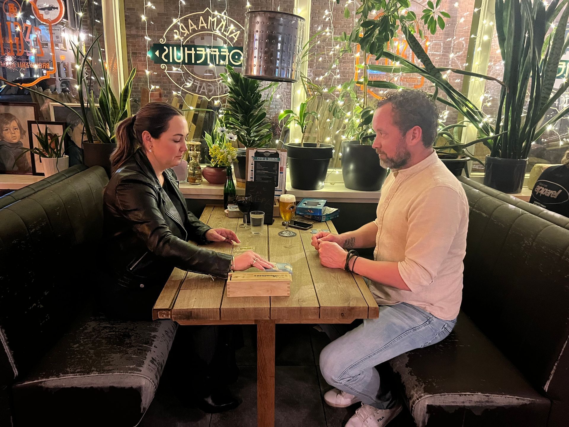 Stel speelt aan tafel een leuk spel met een drankje