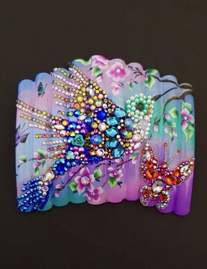 Jeweled bird and butterfly art on a floral background, in shades of blue, purple, and pink.
