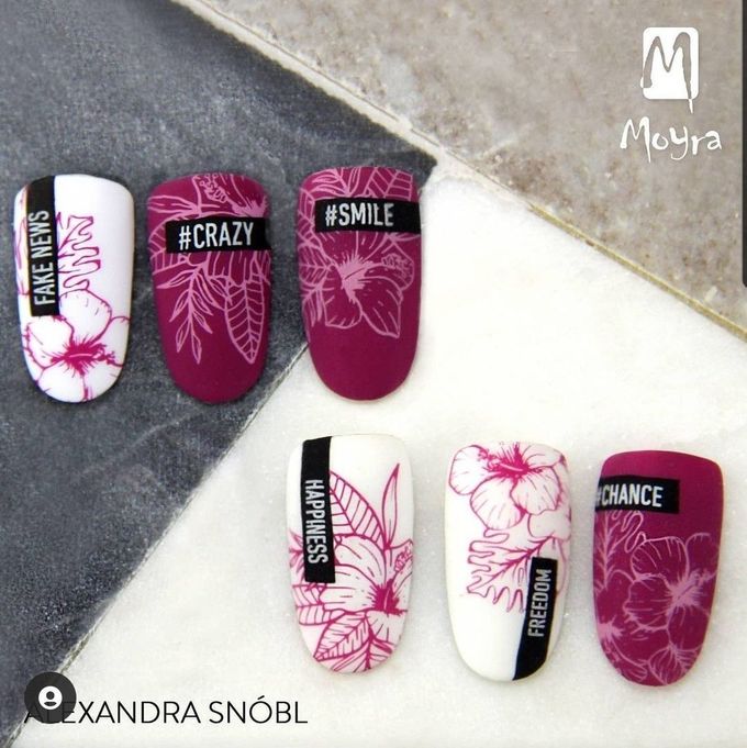 Nail art design with white and burgundy nails, floral outlines, and phrases like