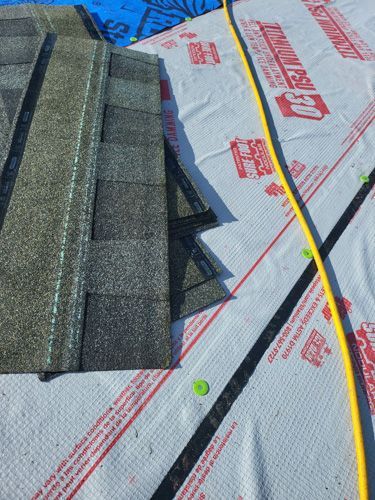 A roof with shingles and a hose on it