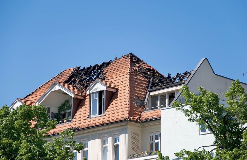 A building with a roof that has been damaged by a fire.