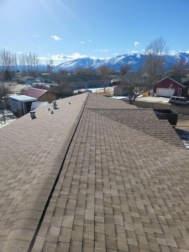 The roof of a house with a view of the mountains in the background.