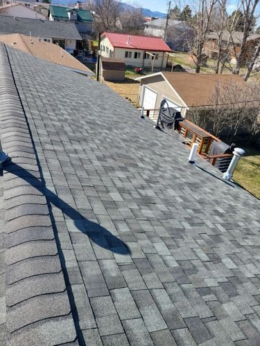 The roof of a house with a gray shingle roof.