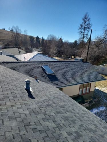 The roof of a house with a skylight on it.